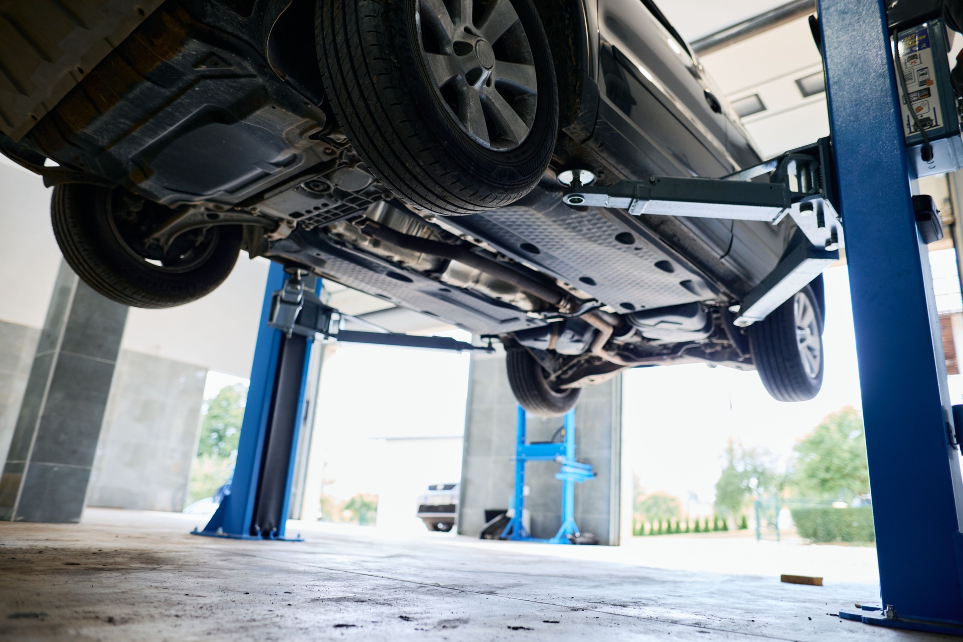 Car lifted on a hydraulic lift in a repair shop for maintenance