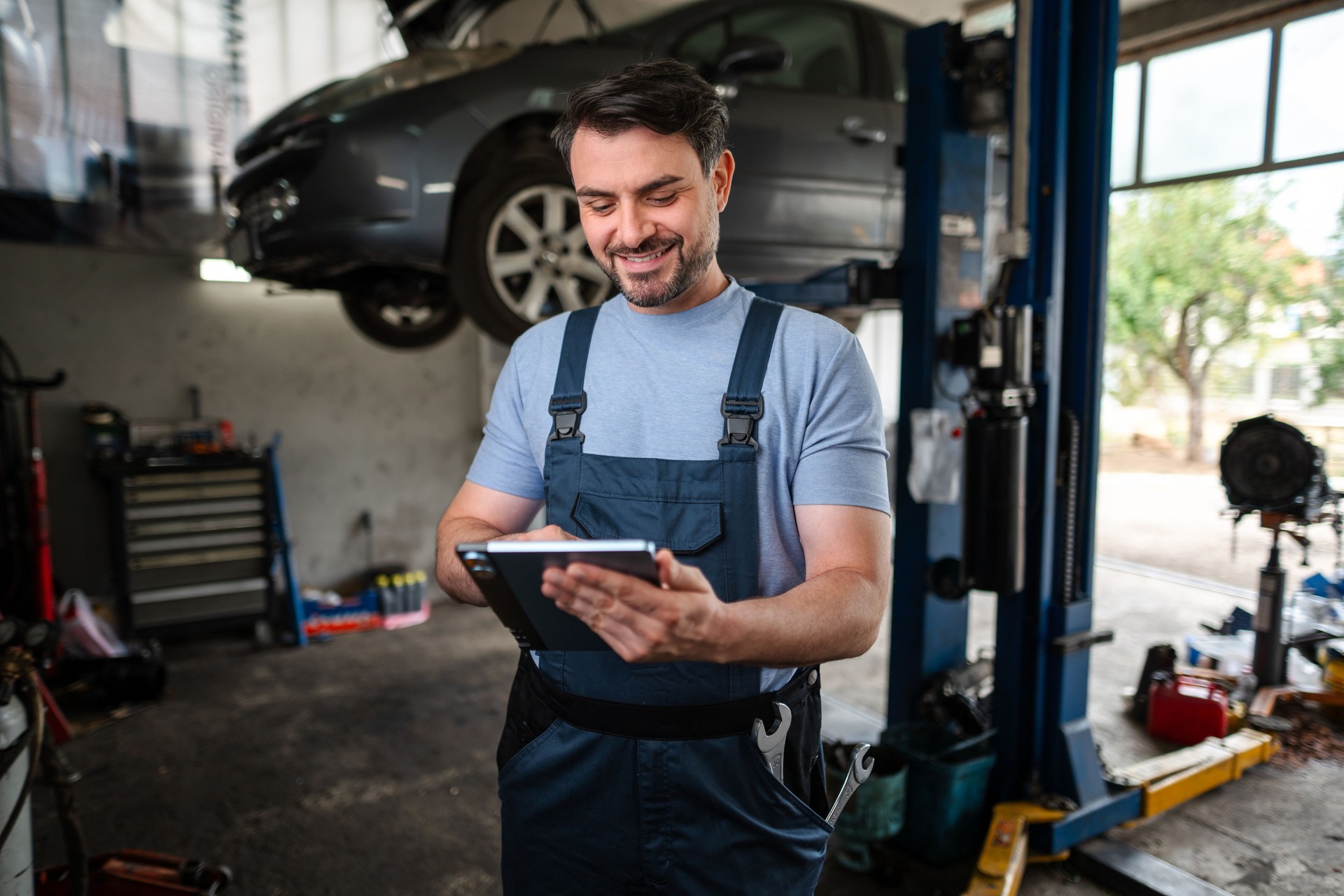 Car mechanic using a digital tablet in a auto repair shop